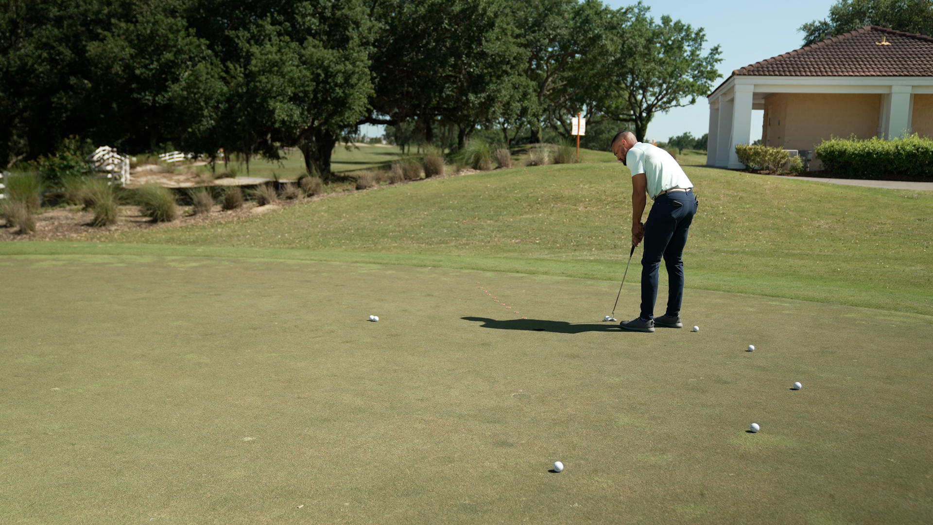 Wooden fishing pier leading towards an arched bridge, as the sunset dips below the horizon. Captree State Park - Long Island New York